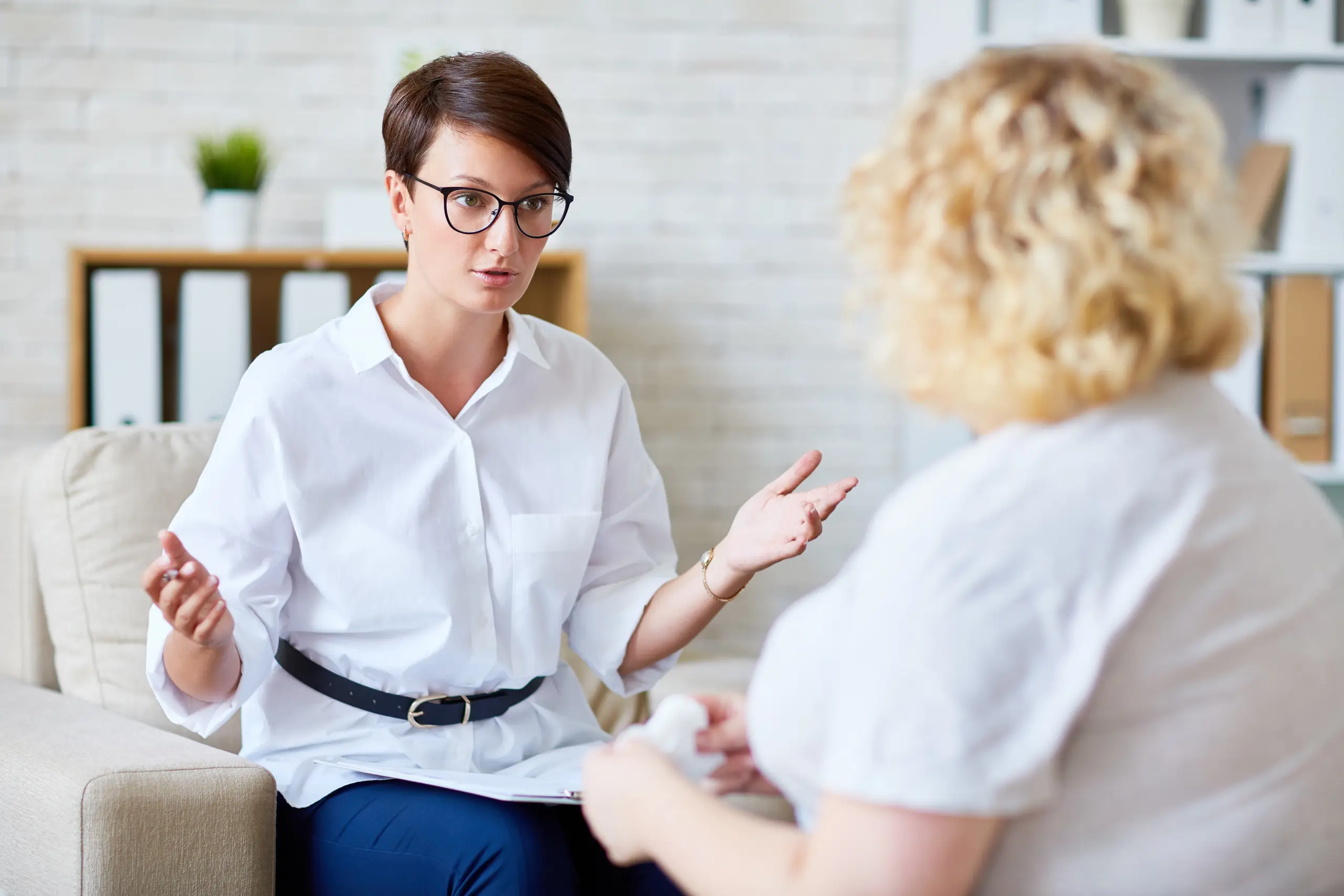 Therapist and client in a supportive conversation, with warm lighting and comfortable surroundings Trauma-informed care session showing support for substance abuse recovery