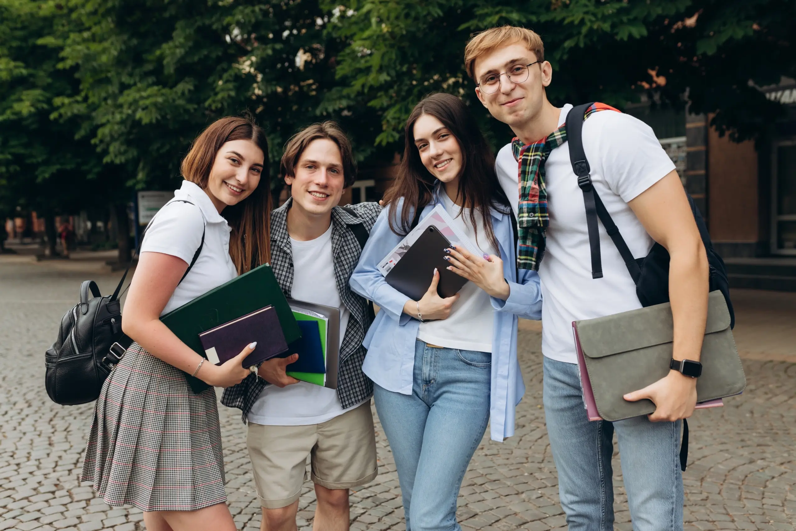 A professional photo of a diverse group of students engaged in a casual, supportive discussion or studying together in a campus common area. Diverse students in a campus setting, representing a collegiate recovery program or sober student support.