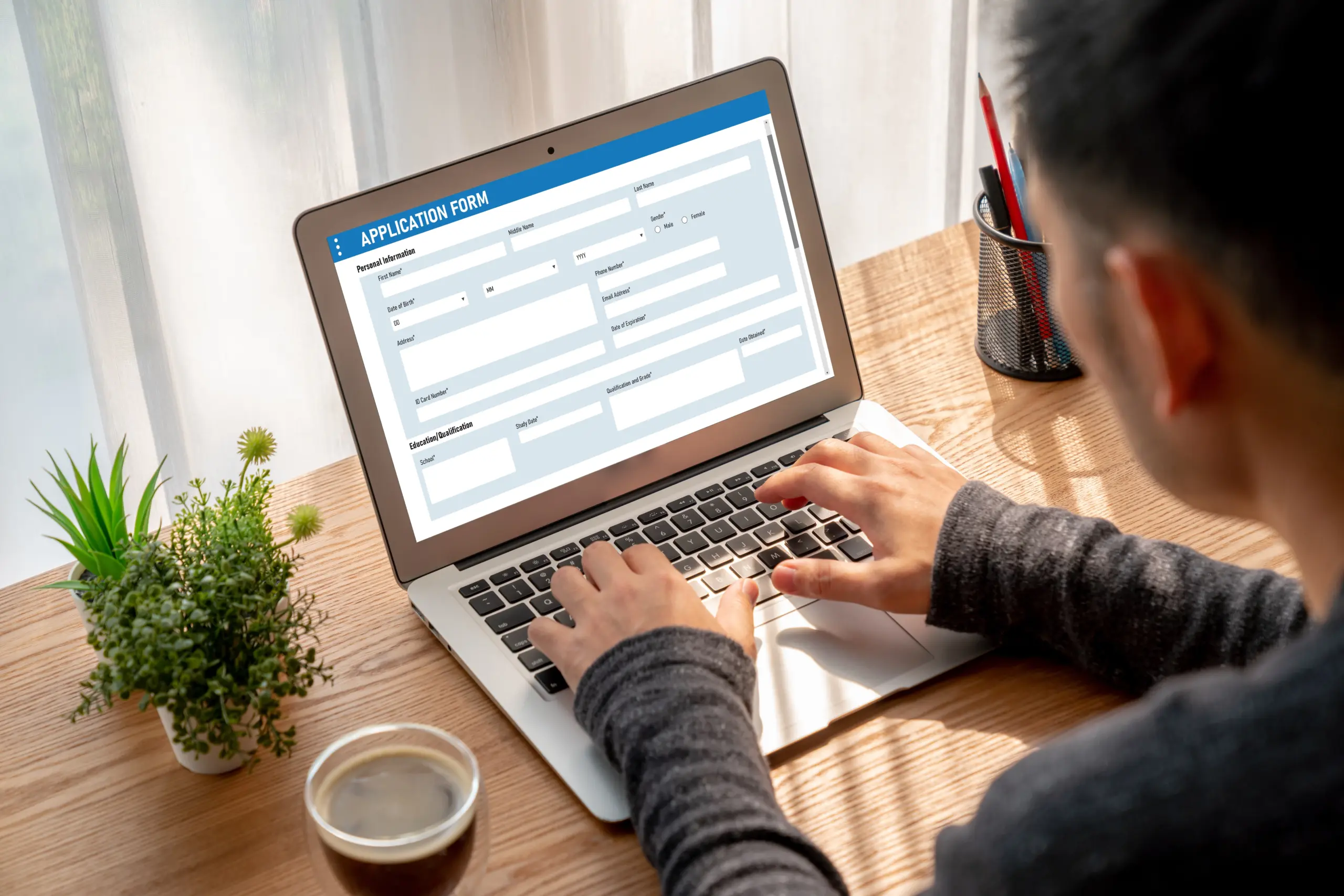 Image A person filling out an online form on a laptop, representing the FAFSA process or scholarship application process Person filling out FAFSA or scholarship application on a laptop.